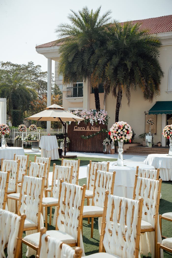 our-services-3 An elegant outdoor wedding setup with chairs, flowers, and decorations.